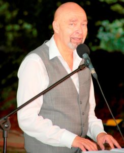 Kabarettist Arnim Töpel bei einem Auftritt am Klavier mit Mikrofon